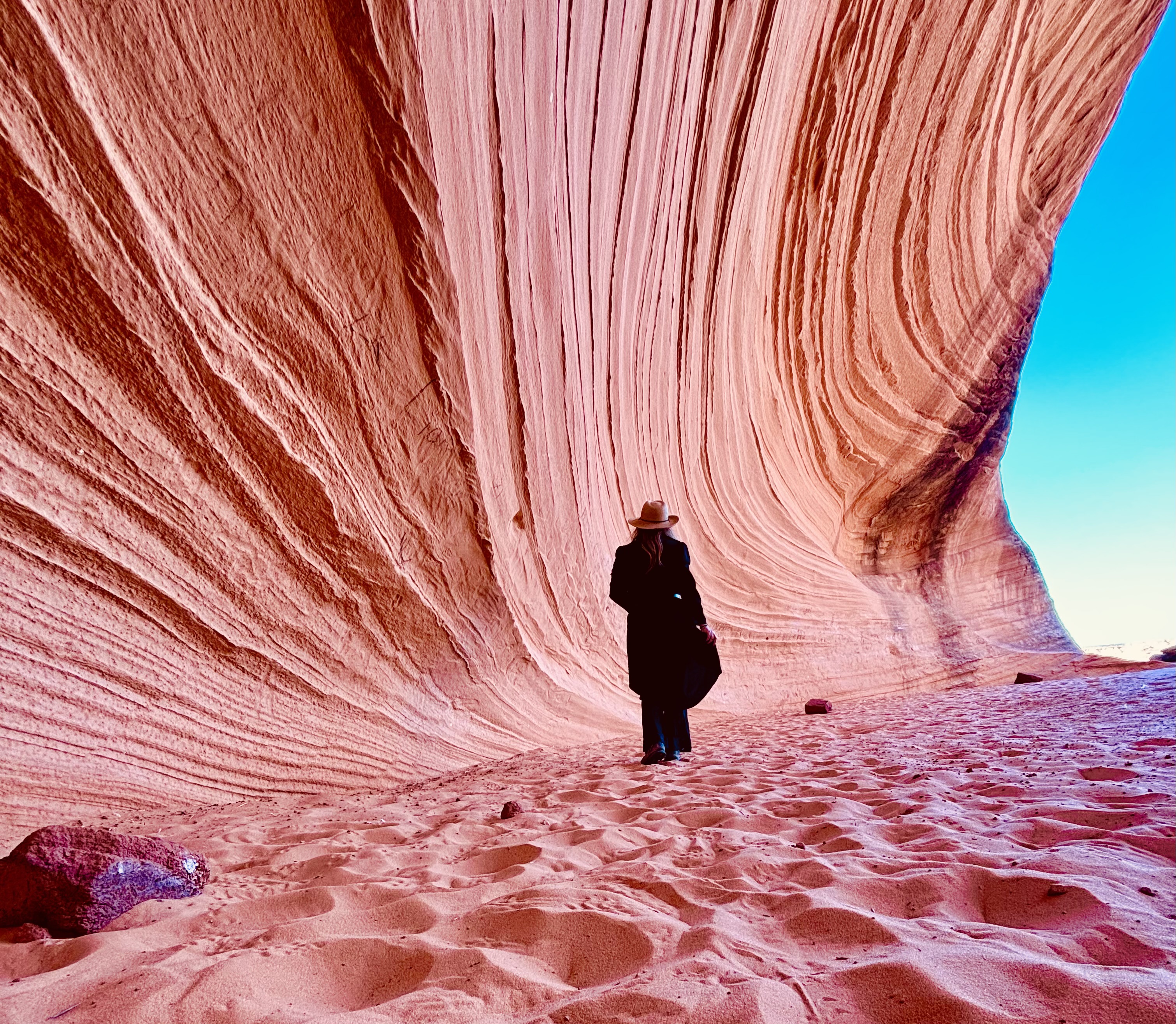 Person walking through a pink sandstone canyon