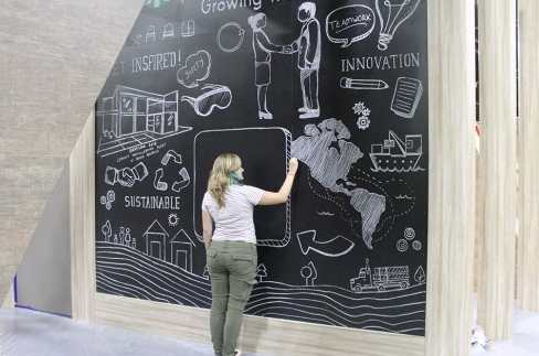 Jessi Queen drawing a sustainability-themed chalk mural